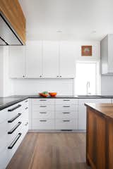 A comprehensive remodel to this traditional kitchen allows for natural light and accommodates the chefs with custom, new cabinetry, storage and a salvaged, customized island. 