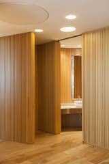 Bath Room, Vessel Sink, Medium Hardwood Floor, Ceiling Lighting, and Metal Counter Main office hidden bathroom  Photo 11 of 17 in Office in Vicente Lopez by MARTIN GOMEZ