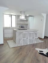 Kitchen, Dishwasher, Cooktops, Wall Oven, Microwave, Tile Counter, White Cabinet, Light Hardwood Floor, Concrete Backsplashe, Refrigerator, Ceiling Lighting, and Undermount Sink Kitchen   Photo 8 of 11 in Bogota downtown by Cesar