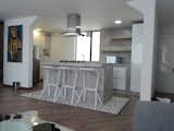 Kitchen, Dishwasher, Refrigerator, Wall Oven, Microwave, Range, Concrete Counter, White Cabinet, Light Hardwood Floor, and Concrete Backsplashe  Photo 11 of 11 in Bogota downtown by Cesar