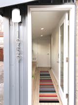 The entry and mudroom features a full length maple plywood storage bench, laundry room and a custom Flor rug.