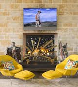 A custom tempered glass fireplace screen adorned with crystals, geodes, and brass details, creates a spectacle to look at when a fire is dancing behind it.