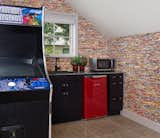 Kitchen, Recessed Lighting, Colorful Cabinet, Granite Counter, Microwave, Refrigerator, Porcelain Tile Floor, and Drop In Sink A small kitchenette, stocked with snacks and drinks, has the walls lined with strips of cinema posters and even has a vintage style arcade game for when they want a break from the screen.   Photo 9 of 9 in Highland Park by Mary Anne Smiley