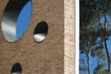 circular windows punctuate the envelope, forming a relationships with the exterior through light
