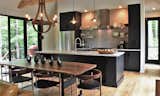 Kitchen, Quartzite Counter, Undermount Sink, Open Cabinet, Light Hardwood Floor, Refrigerator, Subway Tile Backsplashe, Pendant Lighting, Dishwasher, and Range The great room opens completely to the back deck with a Panoramic door system. It blends rustic and contemporary into something comfortable and functional.  Photo 3 of 14 in Appalachian Black Dogtrot by Jay Sifford