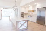 Chef-style kitchen with island detailing, herringbone backsplash, high grade Viking appliances and shiplap range hood.