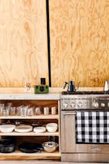 Chef's kitchen detail with open plywood shelves. Range by Thermador