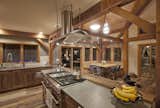 The New Energy Works interior remodel of a 1980s timber frame features reclaimed wood floors from Pioneer Millworks, refreshed cabinetry, lighting, and furniture.