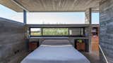 Bedroom, Bed, Wall Lighting, Accent Lighting, Concrete Floor, Wardrobe, Night Stands, Bookcase, Storage, and Shelves  Photo 19 of 34 in Berazategui House by Besonías Almeida arquitectos