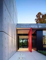 Modern Pivot Door - Extremely large wood pivot door with a custom painted red finish greets visitors to this custom Illinois estate