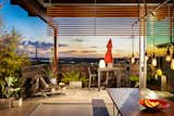 The Neutra inspired "Spiderleg" enables the home dining area to open up on two sides with no visible corner.  The structural leg passes, untouched, through the cantilevered concrete deck to the slope more than 10' below.  