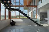 Sleek concrete tread stair meets polished concrete flooring on lower level