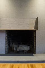 Fireplace Detail with  hammered and striated porcelain tiles and blue stone hearth , plus a raw steel mantel 