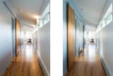 Hallway and Light Hardwood Floor Upstairs Hall with barn doors to close off laundry between boys' bedrooms (in closed & open postions)  Photo 11 of 17 in Pond Vista by Princeton Design Collaborative