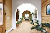 View from the entry foyer towards the central atrium. Handmade Spanish terracotta tile floors are a durable surface for plants and foot traffic. 