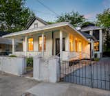 Exterior, Hipped RoofLine, Small Home Building Type, House Building Type, Gable RoofLine, Wood Siding Material, Shingles Roof Material, and Tiny Home Building Type Both homes from the street, with historic gates.  Photo 4 of 8 in A Modern Compound in a Historic City by Chris Bonner