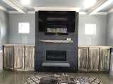 Linear fireplace with 75" Samsung above and custom weathered pine cabinets.