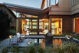 View of reflecting pool and main living spaces.  Rainwater falls in 10-ft waterfall from living roof into reflecting pool.