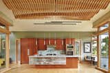 Kitchen with undulating wood screen ceiling over dining area