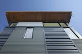 Exterior detail of two different metal siding patters and wood soffit.