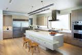 Overall kitchen view, with quartz island, cast-glass breakfast counter, custom steel pendant light fixture and rift-cut oak cabinets.