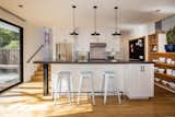 Open kitchen with island supported by reclaimed steel I-beam