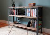 A reclaimed wood and steel bookcase provides ample shelf space in the bedroom.