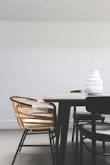 The dining area in the kitchen
Table with concrete top by Made 
Cane armchair: Raphia Rattan by LucidiPevere for Casamania
Pottery vase by Apparatus