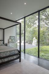 Within each bedroom, the architecture acts as a frame to the landscape beyond. The opening picture faces north towards a sculpted landscape of Japanese maples and native grasses; it is 10' h x 20' w. The stone embedded in the landscape came from the excavated bedrock when construction the home. The colors within each bedroom were selected to compliment the species of plants outside the home.