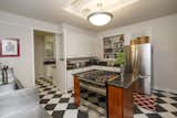 Owners have kept the retro kitchen black and white tile floor, butler pantry, and swinging door