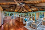 Great room and kitchen has tropical architectural styling with exposed beam ceiling