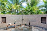 Artisan stone wall with private shower surrounded by lush garden.