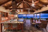 Open concept kitchen and indoor dining area with the giant pocket doors retracted bringing the beautiful Hawaiian sunset into the home.