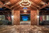 Designed by architect Robert Robinson after a Balinese resort, this Hawaiian estate commands sweeping ocean and multi-island views. The pool is visible, even from the custom front doors, which give off a warm, local vibe through their woven appearance and wood construction.