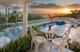 The pool of this palatial Mediterranean style home at sunset