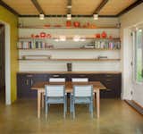 Dining Room, Concrete Floor, Ceiling Lighting, Pendant Lighting, Accent Lighting, Table, Storage, and Chair Modern dining room simplicity.  Photo 6 of 15 in Modern Vermont Farmhouse by Lindsay Selin Photography
