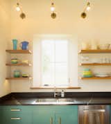 Kitchen, Stone Counter, Accent Lighting, Drop In Sink, Concrete Floor, Pendant Lighting, Open Cabinet, Dishwasher, Wall Lighting, and Wood Cabinet Kitchen vignette  Photo 13 of 15 in Modern Vermont Farmhouse by Lindsay Selin Photography