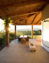 Outdoor, Front Yard, Large Patio, Porch, Deck, Flowers, Hanging Lighting, Gardens, Concrete Patio, Porch, Deck, and Wood Patio, Porch, Deck Porch at dawn overlooking Vermont's Green Mountains.  Porch made from locally harvested wood from the property.   Photo 2 of 22 in Contemporary Vermont Farmhouse by Lindsay Selin Photography