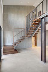 A floating wood and steel stair leads up to the second level.