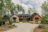 Mountain modern lake house located at Lake Keowee, SC. Natural exterior materials include thermotreated wood cladding and natural stone, blending the home into the nature leaving room for the beautiful mountain and lake views that surrounds this home.