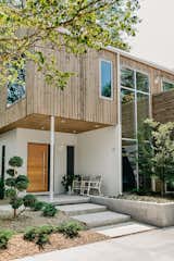 Thermotreated wood cladding in the ceiling of this front porch compliments the stucco walls surrounding it. Solid white oak front door with a sidelight creates inviting entry to the home while keeping it semi private.