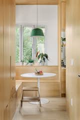 Built in white oak breakfast nook with a bifold corner window creates a cozy spot for morning coffee bringing the outside in