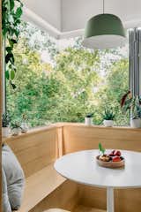 Built in white oak breakfast nook with a bifold corner window creates a cozy spot for morning coffee bringing the outside in
