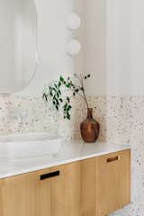 Floating white oak vanity with rectangular cutout handles, true terrazzo tile and minimalist light fixtures