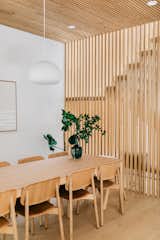 Scandinavian dining room with dining table from Muuto and dining chairs from HAY. The white oak wood slat wall works as a partition wall between the dining space and the staircase.