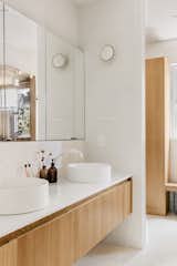 Japandi inspired bathroom featuring minimalist white oak floating vanities with true terrazzo tile on the floors and white finger tiles on the walls
