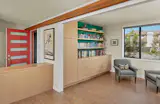 A new library tucked off the front entry houses the family’s book and toy collection, and opens to the expansive living room, dining room, and kitchen area. 