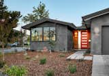 The red door and cedar siding provide a welcome entrance to this family's home.