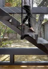 A two-story glass wall and stunning custom stair, crafted from a single piece of folded acid-etched metal. 