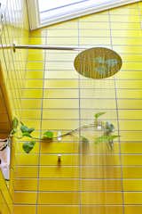 The use of yellow heath tiles and a skylight above create a welcoming guest bath. 